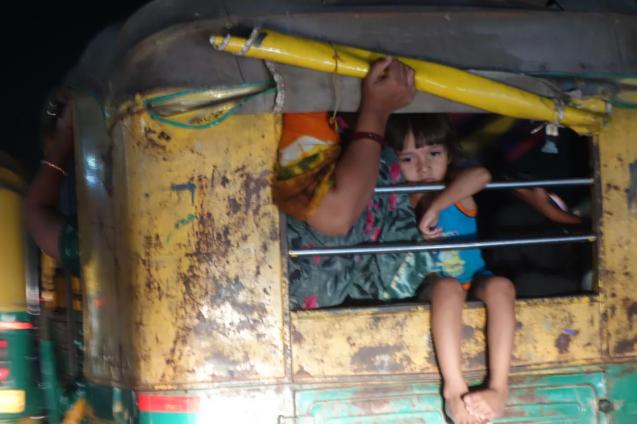A child looking out from a colourful rickshaw