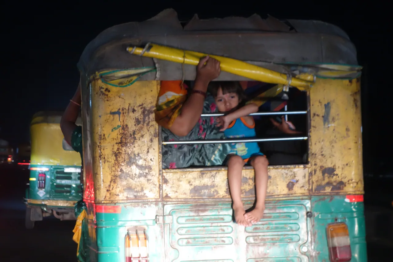 Children peering through the rear window of a rickshaw