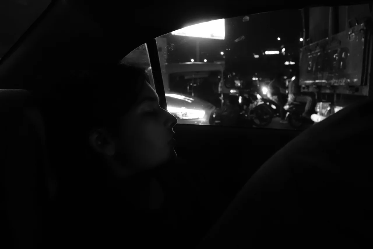 A driver silhouetted against city lights at night
