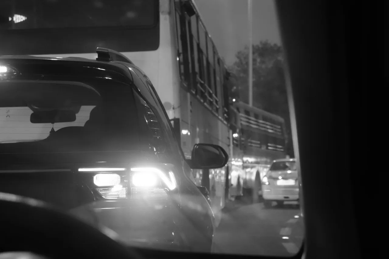 A car approaching with its headlights on at night