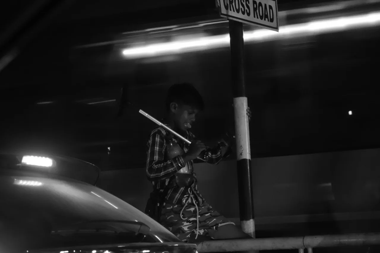 A person walking under fluorescent lights at night
