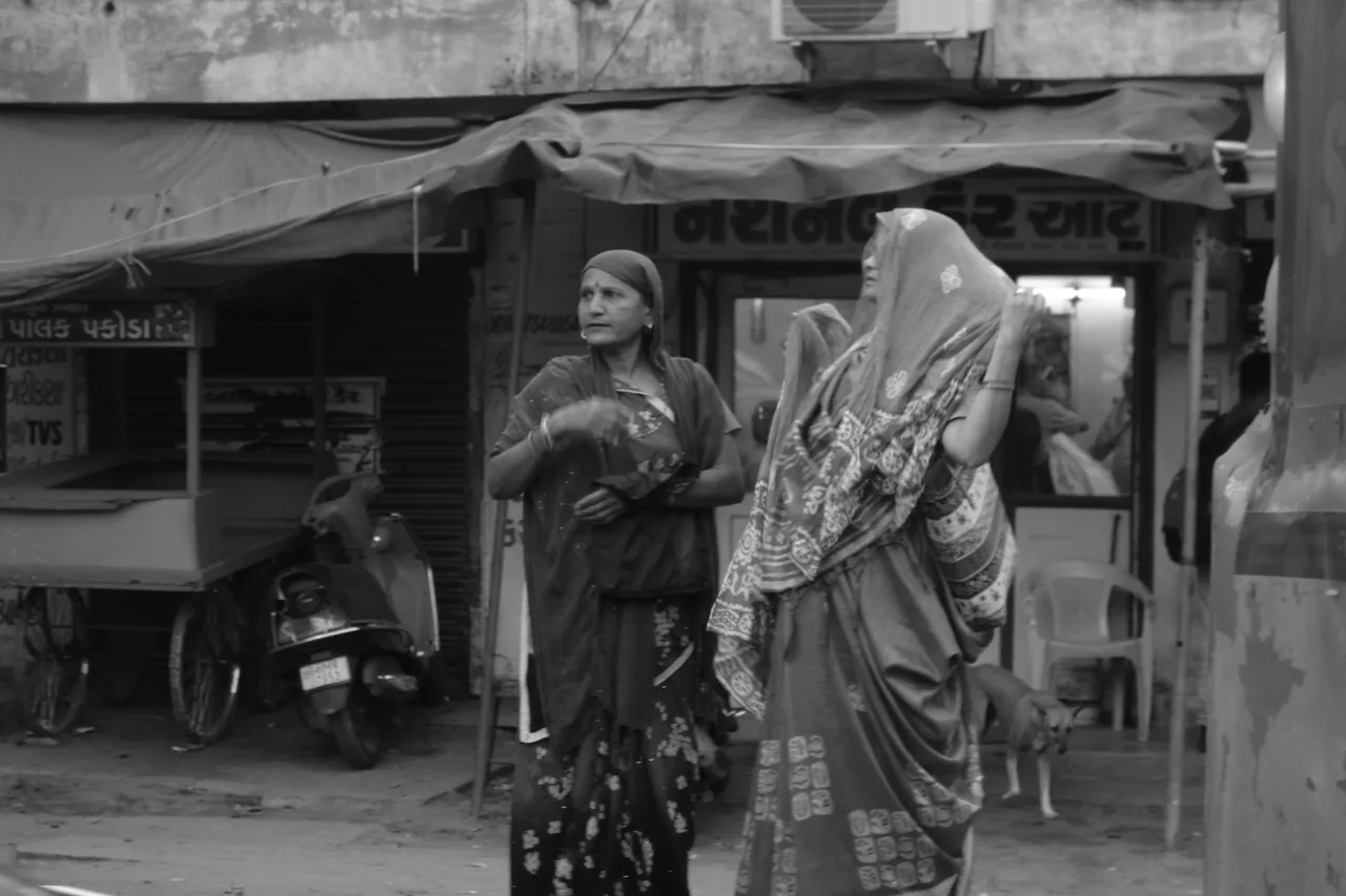 Two women standing outside a roadside shop