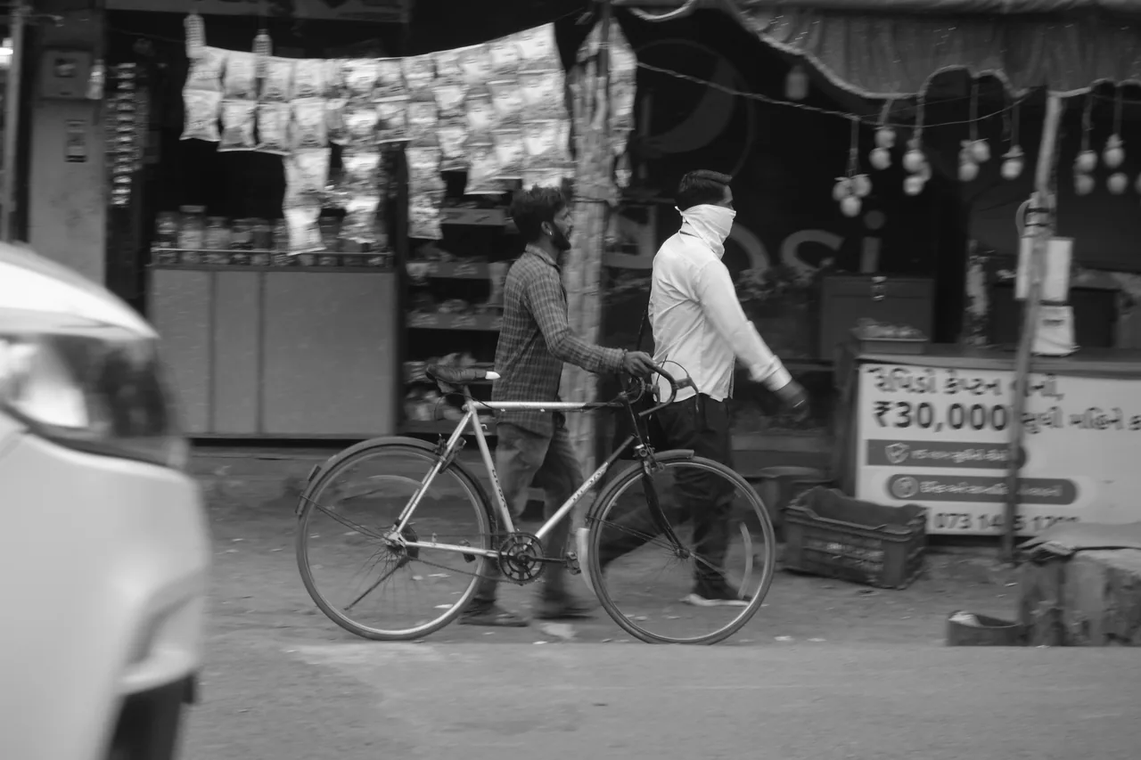 A cyclist passing a row of roadside shops