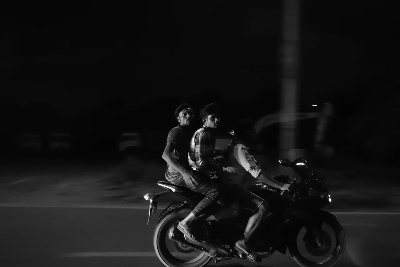 Two people on a motorcycle at night