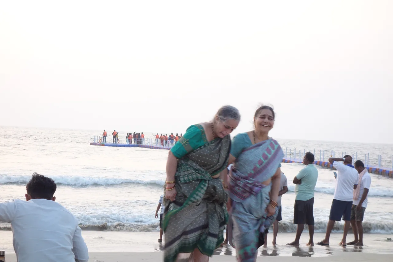 Two women posing together at the edge of the sea